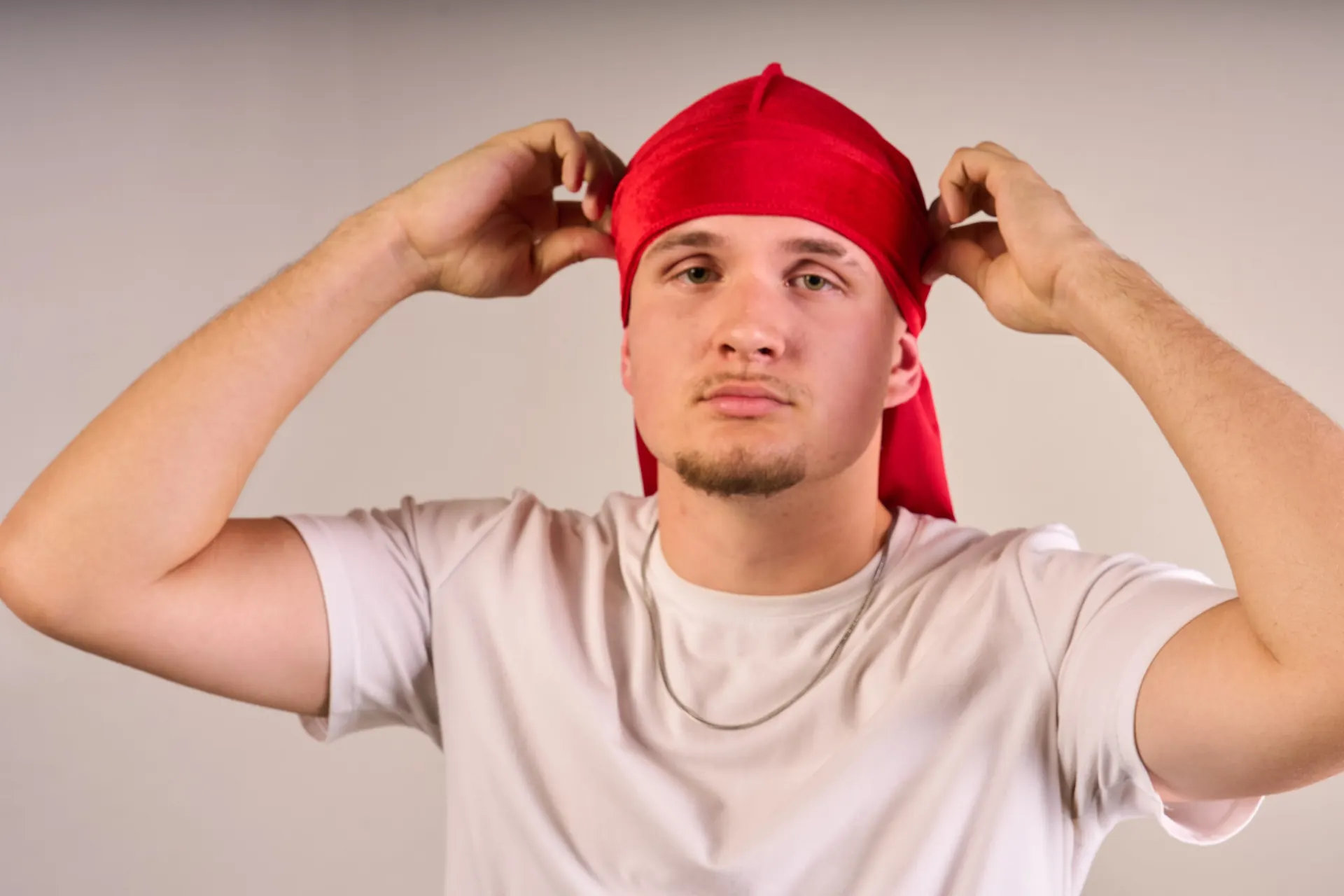 Model zawiązuje czerwony welurowy durag Włocławek