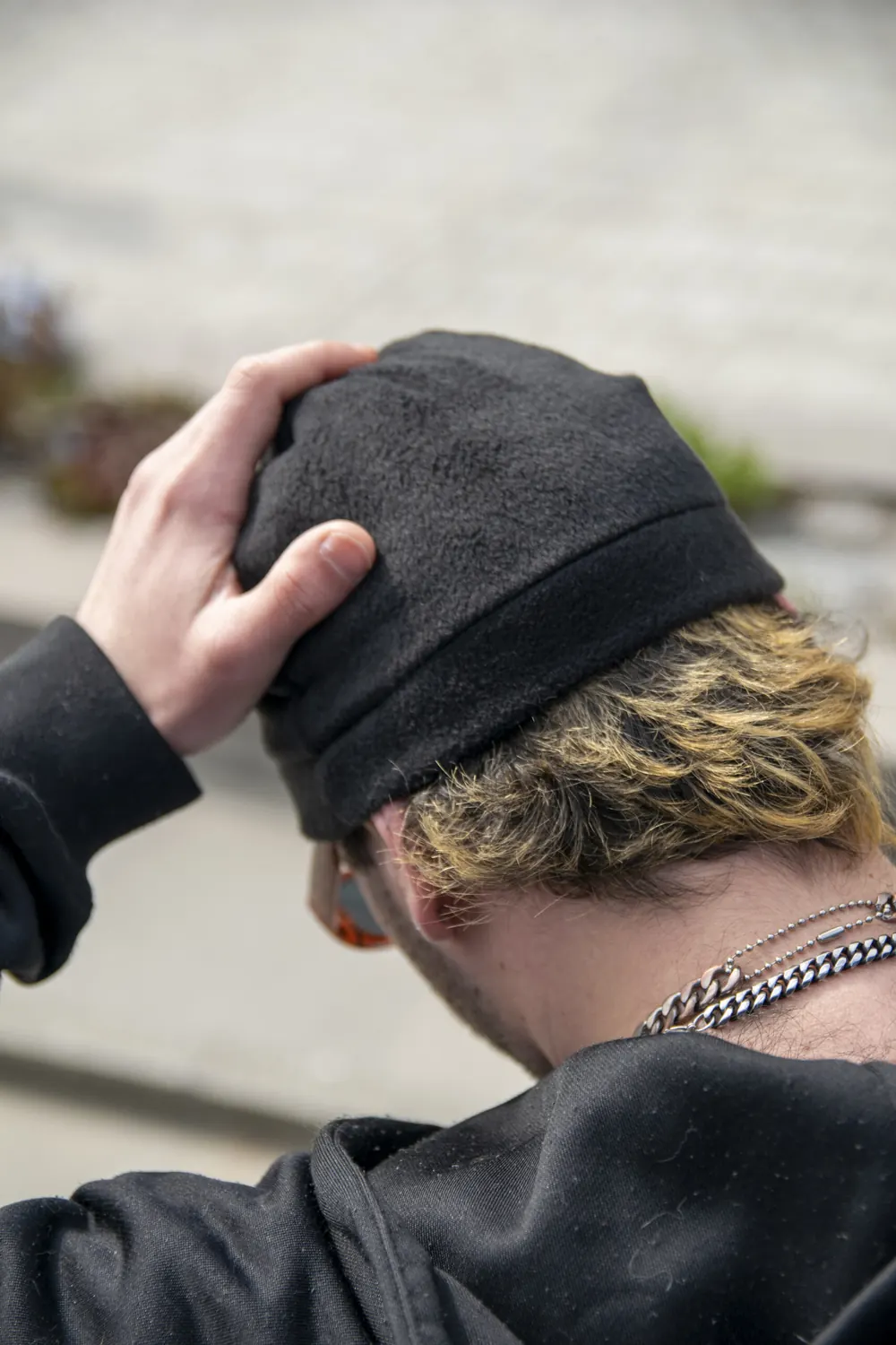 Mężczyzna poprawia czarny Satin Skullcap