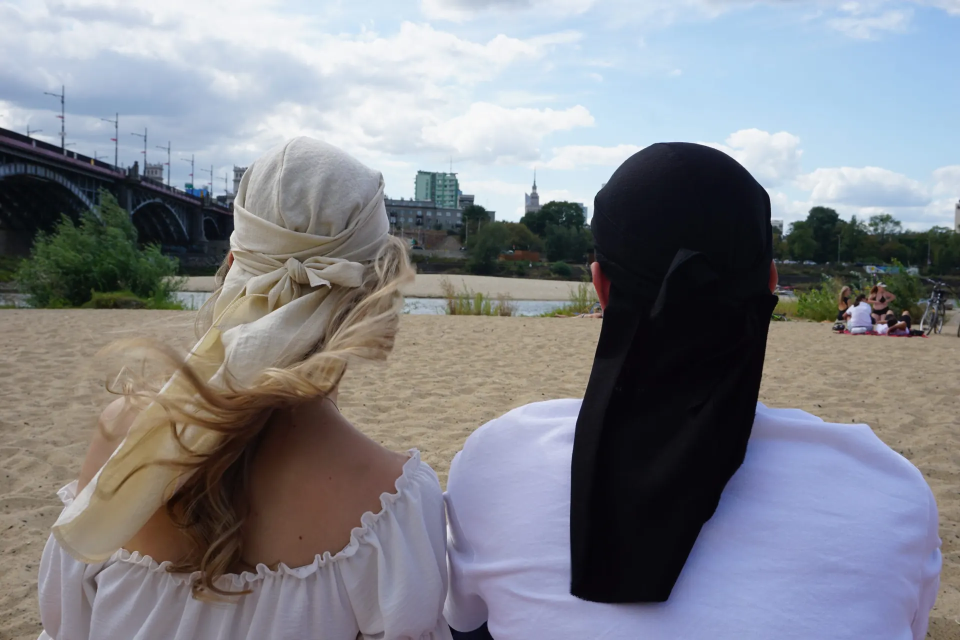 Para na plaży nad Wisłą w lnianych duragach Żyrardów, w tle most i Pałac Kultury