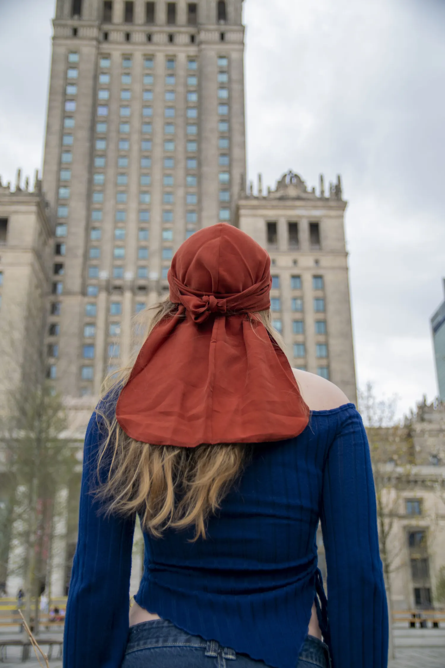 Kobieta w rdzawym duragu Bydgoszcz przed Pałacem Kultury i Nauki